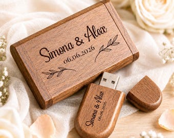 May include: A rectangular wooden USB flash drive case and a matching wooden USB drive with a cap. Both items are engraved with the names Simona & Alex and the date 06.06.2026, accompanied by small leaf illustrations. The wood has a natural grain.