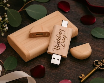Könnte beinhalten: Ein hellbrauner USB-Stick aus Holz mit dem eingravierten Schriftzug "Wedding Day", neben seiner Holzbox und einer Holzkappe. Der USB-Stick hat einen silbernen USB-Anschluss. Der Hintergrund umfasst Rosenblätter und Grün.