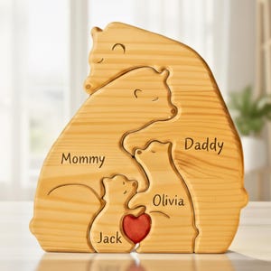 Puede incluir: Rompecabezas de osos familiares de madera con las palabras "Mommy", "Daddy", "Olivia" y "Jack" grabadas. El rompecabezas presenta un coraz&oacute;n rojo y est&aacute; hecho de madera clara.