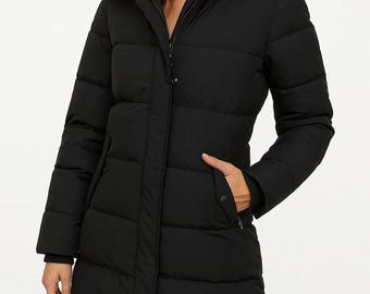May include: A black puffer coat with a faux fur-trimmed hood. The coat has a zip closure, pockets, and a long length. The model is wearing black pants. The coat is designed for cold weather.