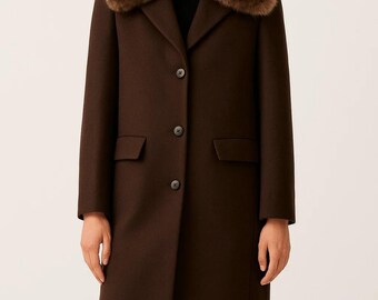 May include: A brown wool coat with a faux fur collar. The coat has a classic design with a notched lapel, two front pockets, and three buttons down the front. The collar is a darker shade of brown than the coat.
