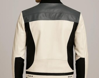 May include: A color-blocked jacket with a black ribbed collar and cuffs. The jacket features a gray upper back panel, a cream-colored center panel, and black side panels. The bottom hem has three small, evenly spaced black dots.