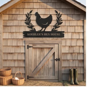 May include: A black metal wall sign featuring a silhouette of a hen centered between two leafy branches. Below the hen, a horizontal rectangular plaque displays the text KOEHLER'S HEN HOUSE in a clean, sans-serif font, mounted on a wooden wall.