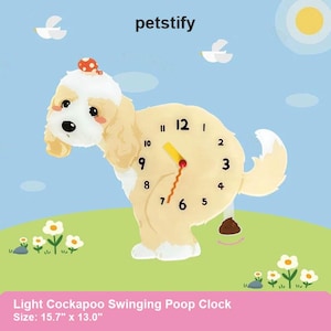 Puede incluir: Un reloj con forma de perro Cockapoo de color claro con una esfera en su cuerpo. El reloj tiene números y manecillas negras. El reloj mide 40 cm de ancho y 33 cm de alto. El reloj está sobre una superficie verde con flores.