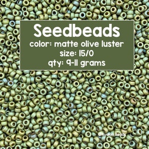 Pode incluir: Uma imagem de close-up de um monte de contas de sementes de cor oliva fosca com brilho. As contas são de tamanho 15/0 e pesam 9-11 gramas. O texto "Seedbeads" está escrito em letras brancas sobre um fundo verde. O texto "color: matte olive luster", "size: 15/0" e "qty: 9-11 grams" também está escrito em letras brancas sobre um fundo verde.