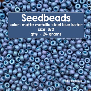 Pode incluir: Uma imagem de close-up de um monte de contas de sementes de aço metálico azul lustroso fosco. As contas são de tamanho 8/0 e pesam aproximadamente 24 gramas. O texto "Seedbeads" está escrito em letras brancas sobre um fundo azul. O texto "color: matte metallic steel blue luster" está escrito em letras brancas sobre um fundo azul. O texto "size: 8/0" está escrito em letras brancas sobre um fundo azul. O texto "qty: ~ 24 grams" está escrito em letras brancas sobre um fundo azul. O texto "Avalon Beads" está escrito em letras brancas sobre um fundo azul.