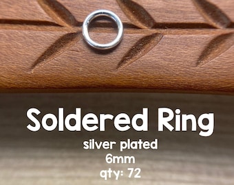 May include: Silver plated soldered ring, 6mm in diameter, on a wooden surface.  Qty: 72. ©Avalon Beads