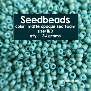 Pode incluir: Close-up de contas de sementes opacas foscas em cor espuma do mar. As contas são do tamanho 11/0 e pesam aproximadamente 24 gramas. O texto na imagem diz "Seedbeads" e "Avalon Beads".