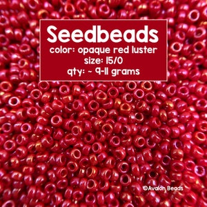 Pode incluir: Uma imagem de close-up de contas de sementes vermelhas, aproximadamente 9-11 gramas, no tamanho 15/0. As contas têm um acabamento vermelho opaco brilhante. O texto "Seedbeads" está escrito em letras brancas sobre um fundo vermelho, juntamente com os detalhes "color: opaque red luster", "size: 15/0", e "qty: ~ 9-11 grams".