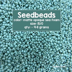 Pode incluir: Uma imagem de close-up de um monte de contas de sementes de cor verde espuma do mar fosco opaco. As contas são de tamanho 15/0 e pesam aproximadamente 9-11 gramas. O texto "Seedbeads" está escrito em branco sobre um fundo verde escuro. O texto "color: matte opaque sea foam" está escrito em branco sobre um fundo verde escuro. O texto "size: 15/0" está escrito em branco sobre um fundo verde escuro. O texto "qty: ~ 9-11 grams" está escrito em branco sobre um fundo verde escuro. O texto "Avalon Beads" está escrito em branco sobre um fundo verde escuro.