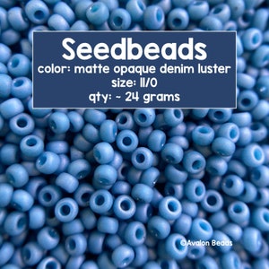 Pode incluir: Uma imagem de close-up de um monte de pequenas contas de sementes azuis claras. As contas são de cor denim mate opaco e tamanho II/O. O texto na imagem diz "Seedbeads", "color: matte opaque denim luster", "size: II/O", "qty: ~ 24 grams" e "Avalon Beads".