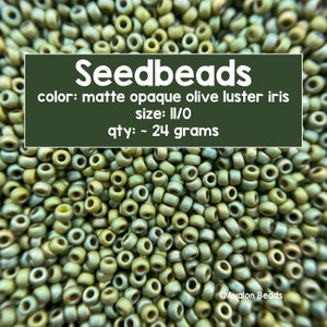 Pode incluir: Close-up de um monte de contas de sementes de íris verde-oliva opaco fosco. As contas são de tamanho II/O e pesam aproximadamente 24 gramas. Contas de sementes, cor: íris verde-oliva opaco fosco, tamanho: II/O, quantidade: ~ 24 gramas