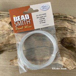 Puede incluir: Un paquete de alambre de cuentas de plata con n&uacute;cleo de cobre. El paquete est&aacute; etiquetado como "The Bead Smith Bead Wire" e incluye los detalles: "Silver Wire with copper core 0.80 MM Length 6m 20 Gauge".
