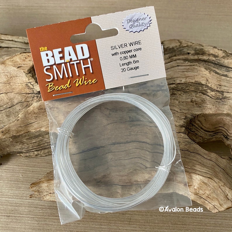 Puede incluir: Un paquete de alambre de cuentas de plata con n&uacute;cleo de cobre. El paquete est&aacute; etiquetado como "The Bead Smith Bead Wire" e incluye los detalles: "Silver Wire with copper core 0.80 MM Length 6m 20 Gauge".