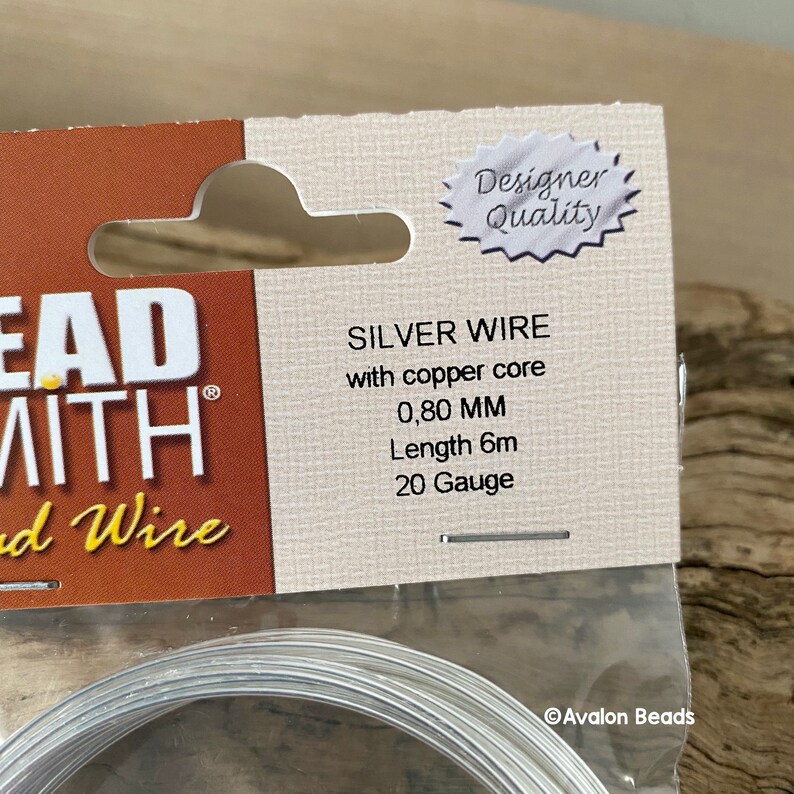 Puede incluir: Alambre plateado con n&uacute;cleo de cobre, 0,80 mm de grosor, 6 metros de largo, calibre 20. El alambre est&aacute; empaquetado en una tarjeta blanca con el texto "Beadsmith" y "Designer Quality" impreso en ella.