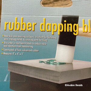 May include: A rubber dapping block with a non-skid surface, ideal for flattening wire and securing parts. The block measures 10.16 cm x 10.16 cm x 2.54 cm and is made of firm vulcanized rubber. The text "rubber dapping block" is visible.