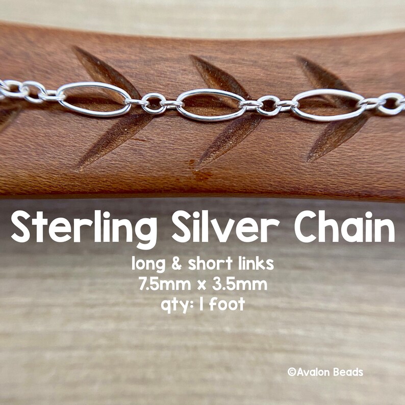 May include: A sterling silver chain with long and short oval links. The chain links measure 7.5mm x 3.5mm. The image shows the chain against a wooden surface. The text "Sterling Silver Chain" is displayed.