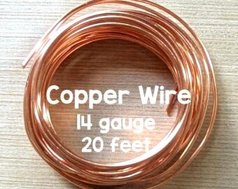 May include: A coil of shiny metallic copper wire. The text printed over the center of the coil reads: Copper Wire, 14 gauge, 20 feet. The wire is wound into a circular shape with a consistent thickness throughout the entire length of the coil.