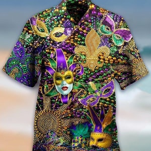 Peut inclure: Chemise à manches courtes avec un thème Mardi Gras vibrant. La chemise présente un collage de masques, de fleur de lys et de perles en or, vert, violet et jaune. Le motif est placé sur un fond de perles scintillantes, créant un look festif.