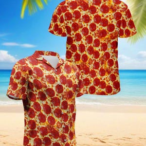 Puede incluir: Dos camisas de manga corta con botones con un patrón de pepperoni de pizza. Las camisas tienen cuello y botones blancos. El fondo es una escena de playa con palmeras, cielo azul y océano.