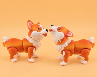 May include: Two orange and white corgi dog figurines. One dog is looking at the other with its tongue out. The other dog is looking up with its mouth open. The figurines have articulated joints.