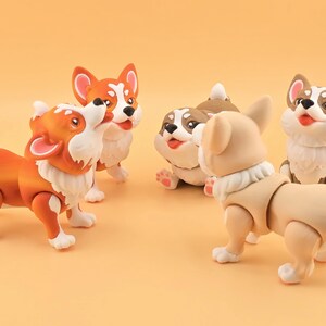 Pu&ograve; includere: Una collezione di cinque statuette di cani corgi in varie pose. Le statuette sono principalmente arancioni, marroni e beige, con dettagli bianchi. Hanno giunture articolate e sono su uno sfondo arancione.