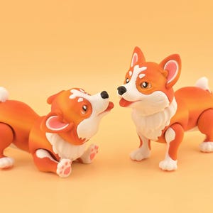 Pu&ograve; includere: Due statuette di corgi arancioni e bianchi. Uno &egrave; sdraiato, che guarda l'altro, in piedi. I corgi hanno petto, zampe e punte della coda bianche. Lo sfondo &egrave; di un arancione chiaro uniforme.