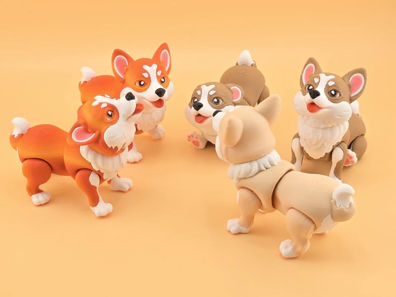 Pu&ograve; includere: Una collezione di cinque statuette di cani corgi in varie pose. Le statuette sono principalmente arancioni, bianche e beige, con giunture articolate. I cani hanno facce espressive e sono ambientati su uno sfondo arancione chiaro.