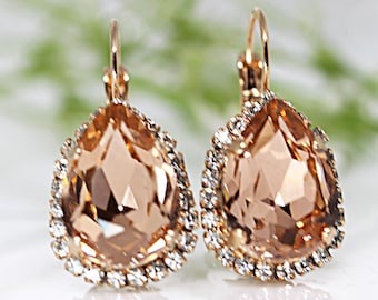 Pendientes colgantes de cristal color melocotón rosado, chapados en oro rosa.