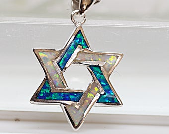 May include: A silver chain necklace with a pendant in the shape of a six-pointed star. The star is made of white and blue opal.