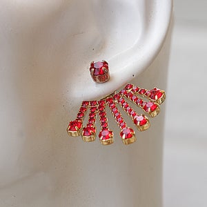May include: Gold earrings with a red crystal cluster in a fan shape.