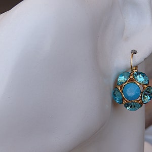 Puede incluir: Pendientes colgantes de oro con un racimo de cristales azul turquesa.