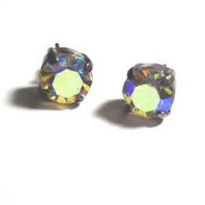 May include: A pair of iridescent yellow stud earrings with a silver setting.