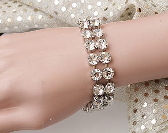 May include: A silver bracelet with multiple rows of clear crystal rhinestones.