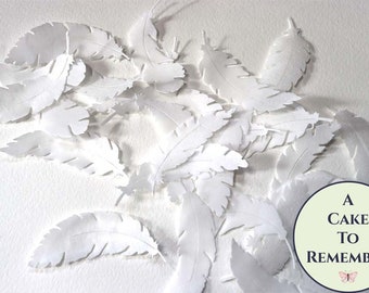 24 medium white edible wafer paper feathers in various shapes. Edible feathers for a unique wedding or birthday cake topper