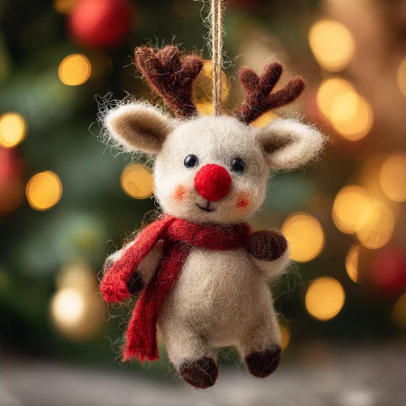 Puede incluir: Adorno navide&ntilde;o artesanal con forma de reno. El reno tiene un cuerpo color crema, cuernos marrones y una nariz y bufanda rojas. Colgante de una cuerda natural, es perfecto para decorar durante las fiestas navide&ntilde;as.