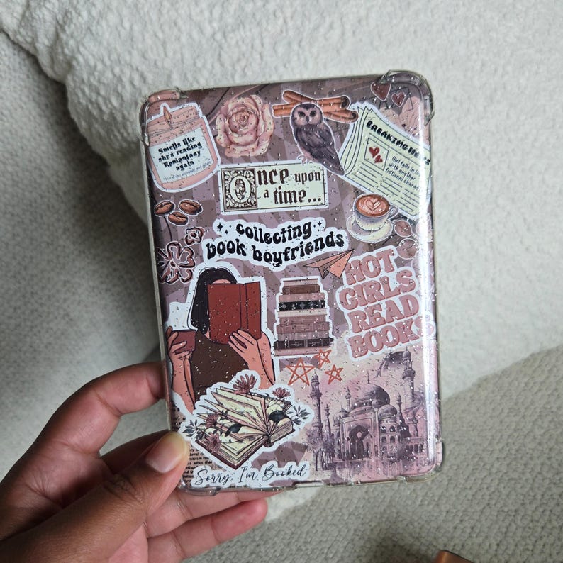 Op de afbeelding: Een rechthoekige telefoonhoes met stickers in bruin, roze en wit. De stickers bevatten illustraties van boeken, een uil en teksten als "Collecting book boyfriends" en "Hot girls read books".