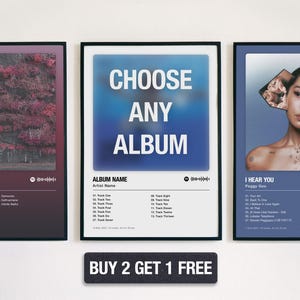 May include: Three framed album art prints. The left print features a dark red and purple image with the text "IN ARCADIA" and "Token". The centre print says "CHOOSE ANY ALBUM". The right print says "I HEAR YOU" by Peggy Gou.
