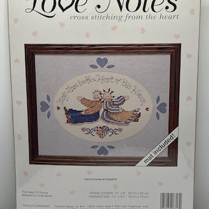 May include: A cross-stitch kit titled "Love Notes" featuring a framed design with the text "May Love be the Heart of this Home." The kit includes a charted design, floss, needle, and instructions. Finished size is 7.5" x 5.125".