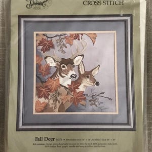 May include: A cross-stitch kit featuring a fall scene with two deer and autumn leaves. The kit is labeled "Fall Deer" and includes the text "Something Special" and "COUNTED CROSS STITCH". The finished size is 14 x 14 inches, and the matted size is 18 x 18 inches.