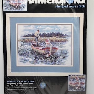 May include: A Dimensions stamped cross stitch kit titled "Waterlily Blossoms" designed by Richard Judson Zolan. The kit includes cotton thread, printed white sailcloth, needle, and instructions. The fabric size is 18 x 14 inches (46 x 36 cm). The kit features a cross-stitch design of people in a boat.