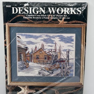 May include: A Design Works counted cross stitch kit, number 9682, measuring 12 inches by 16 inches. The packaging features a nautical scene with wooden buildings, boats, and a dock in a snowy landscape, framed in a brown border with starfish.