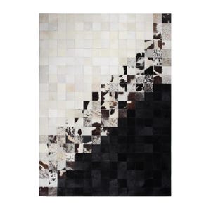 May include: A rectangular cowhide rug with a geometric design. The rug transitions from white squares to a mix of black, brown, and white patterned squares, culminating in solid black squares. The design creates a diagonal gradient effect.