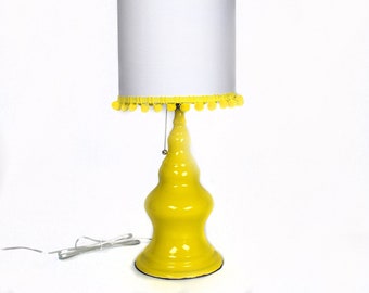 Tall yellow ceramic lamp with pompom shade