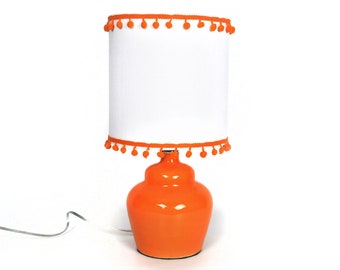 Small orange ceramic lamp with pompom shade