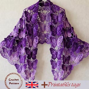 Peut inclure: Un châle en crochet violet composé d'un motif répétitif de papillons. Le vêtement est construit à partir de papillons en fil entrelacés dans diverses nuances de violet et de lavande. Le texte en bas indique Crochet Pattern + Printables tags.