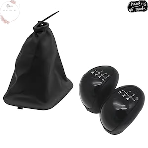 May include: Black car gear shift knobs and a black shift boot. The knobs have white markings for the gears, including reverse. The shift boot is made of a soft, flexible material and has a drawstring closure.