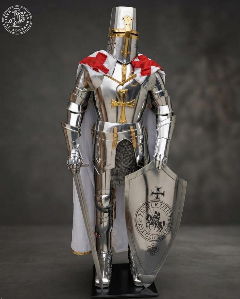 K&ouml;nnte beinhalten: Eine vollst&auml;ndige R&uuml;stung aus poliertem Stahlblech mit einem Helm mit goldenem Kreuz, einem wei&szlig;en Umhang mit roten Kreuzen und einem Brustpanzer mit goldenem Kreuzemblem. Die R&uuml;stung umfasst einen Metallschild mit Siegel und ein langes Stahlschwert.