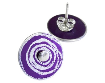 May include: A pair of purple and white enamel earrings with a swirl design. The earrings are silver toned and have a post back.