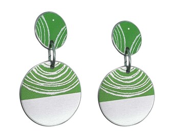 May include: A pair of green and white dangle earrings with a circular design. The top circle is green with white lines and the bottom circle is white with green lines.